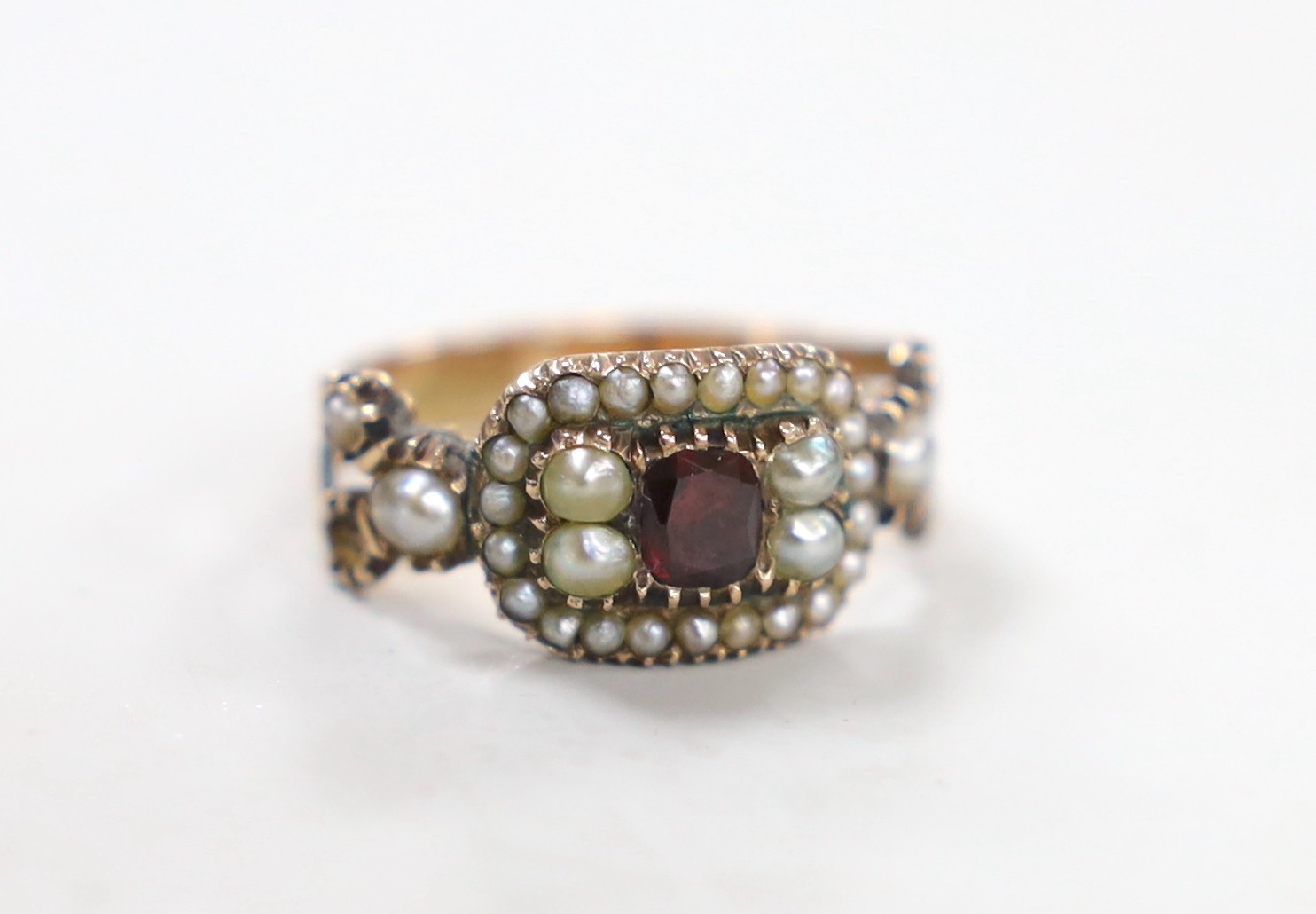 A 19th century yellow metal, foil backed? garnet and split pearl set ring (repair), size O/P, gross 3.6 grams.